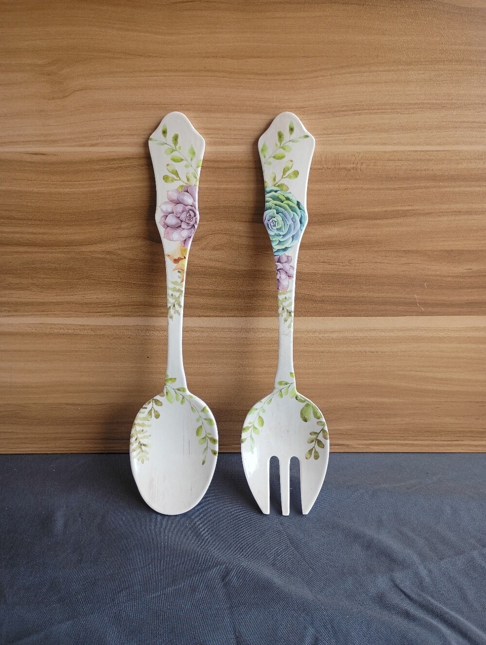 Decorative white salad serving set featuring a spoon and a fork